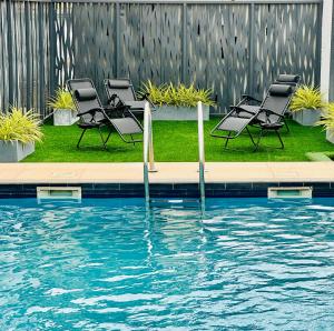 een groep stoelen naast een zwembad bij Jessica's Villa Apt 2 in Accra