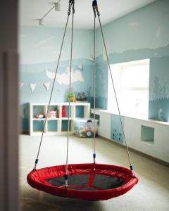 a red tire swing hanging from the ceiling in a room at Focus Hotel Premium Elbląg in Elblag