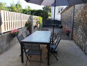 een tafel en stoelen met een parasol op een terras bij Maison de vacances in Languidic