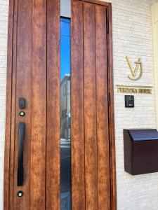 a wooden door on a building with a sign on it at VJ House in Fukuoka