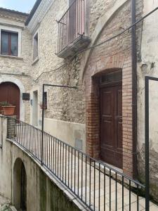 a brick building with a wooden door and a fence at Casa Di Poeta in Casacalenda
