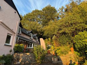 une maison avec des arbres et des buissons devant elle dans l'établissement Chineway Cottage, à Ottery St Mary