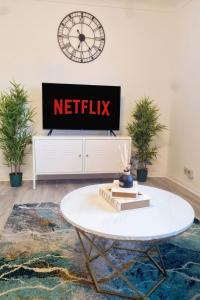 Una sala de estar con televisión y una mesa de café. en Chelmsford Getaway Business and Leisure, 