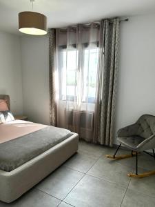a bedroom with a bed and a chair in it at L'Ostal Des Amis in Servian