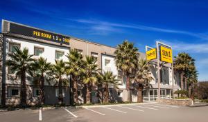 约翰内斯堡SUN1 O.R.TAMBO的停车场前有棕榈树的酒店