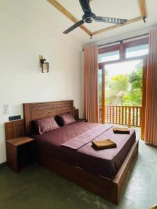 a bedroom with a large bed and a balcony at Leema hiriketiya in Nilwella