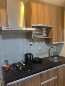 a kitchen with a stove top and a microwave at Condominio Irala in Santa Cruz de la Sierra +7 photos