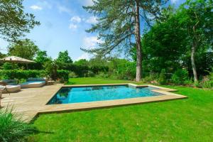 a backyard with a swimming pool and a lawn at Demeure Architecte avec Piscine Privee in Le Vésinet