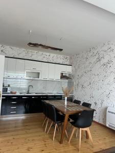 a kitchen with a wooden table and black chairs at SunHill Villa in Shkodër