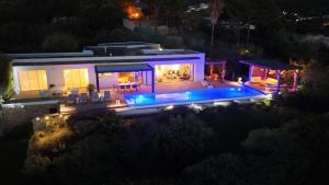 una vista aerea di una casa con piscina di notte di Giulia, villa exceptionnelle, vue mer et Ajaccio a Porticcio Altre 60 foto