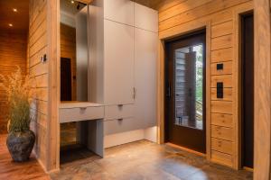 a hallway with wooden walls and a door and a window at Aurora B Luxury Lodge in Kuusamo +30 photos