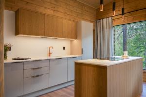 a kitchen with white cabinets and a large window at Aurora B Luxury Lodge in Kuusamo