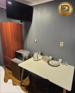 a kitchen with a white table and a microwave at Hostal HDQ en Concepción Sector Collao in Concepción