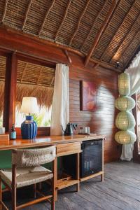 a room with a wooden desk with a lamp and chairs at Supersenang Boutique Resort Balian in Balian