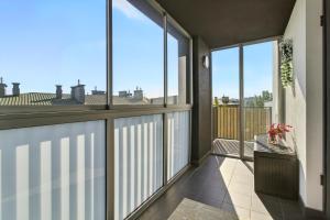 a balcony with large windows and a view of the city at Pełczyńskiego Comfort Stay by Solarento in Warsaw