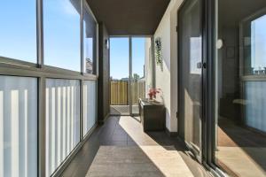 a hallway with glass doors and a floor to ceiling window at Pełczyńskiego Comfort Stay by Solarento in Warsaw