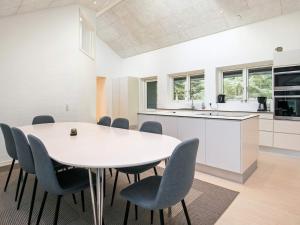 a white kitchen with a table and chairs at 14 person holiday home in Løkken in Løkken