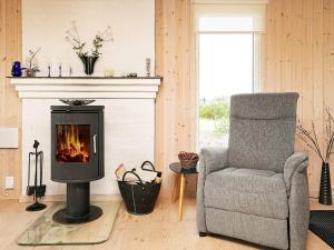 a living room with a chair and a fireplace at Cozy Coastal Retreat in Vorupor-By Traum in Thisted
