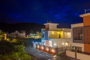 a large white building at night with lights at Sanjana's villa in Malavli