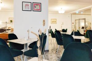 a restaurant with tables and chairs and a mirror at Garner Hotel Vienna - Prinz Eugen by IHG in Vienna