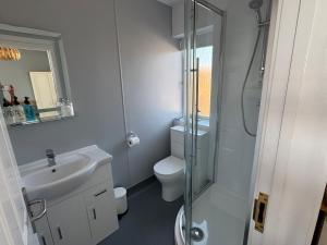 a bathroom with a toilet and a sink and a shower at Mariners Hotel in Seaton