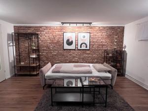 a room with a bed and a brick wall at Private Apartment & rooms near fairground Hannover in Hannover +12 photos