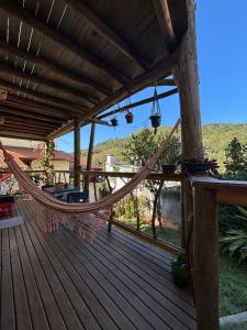 uma rede no convés de uma casa em Quarto com banho privado e lavanderia em Florianópolis mais 13 fotografias