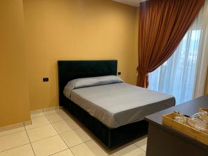 a bedroom with a bed and a window at Oasi Urbana in Casoria