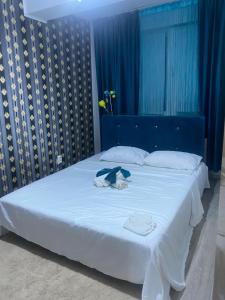 una camera da letto con un letto con lenzuola bianche e tende blu di Golden House Apartments a Cluj-Napoca