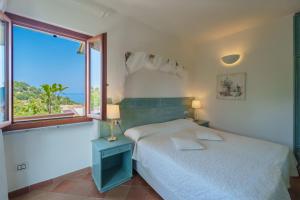a bedroom with a bed and a large window at Hotel Gallo Nero in SantʼAndrea +100 photos