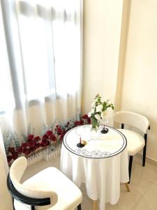 胡志明市The Writeriana de Lumière的一张白色的桌子,上面有花瓶