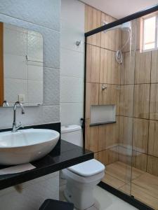 une salle de bain avec un lavabo, des toilettes et une douche dans l'établissement Apartamento em condomínio resort no litoral sul, à Parnamirim