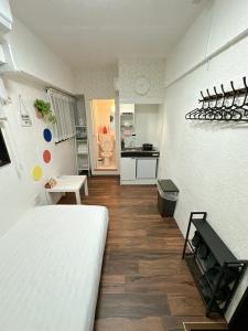 a bedroom with a white bed and a kitchen at Katsu hotel #2 in Osaka