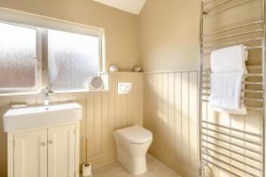 une salle de bain avec toilettes, lavabo et fenêtre dans l'établissement The Mill House, à Hindolveston 20 autres photos