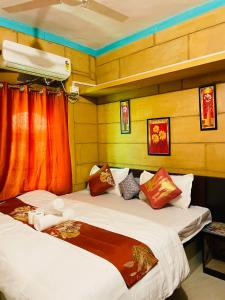 two beds in a room with red curtains at Ok-An Homestay in Jaisalmer