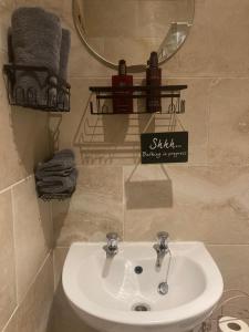 a bathroom with a sink and a mirror and towels at Daisys Rest in Redcross