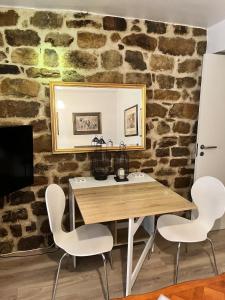 une salle à manger avec une table en bois et des chaises blanches dans l'établissement La Petite Bastide-Central Apartment in Neffies, à Néffiès
