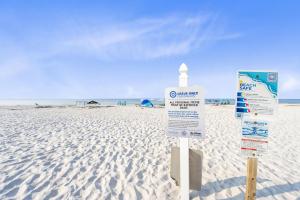 two signs on a beach with the ocean in the background at Laguna Bella in Gulf Shores
