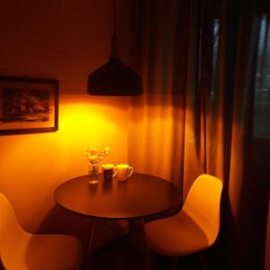 a small table with two chairs and a table with flowers at Belas guesthouse in Kazbegi