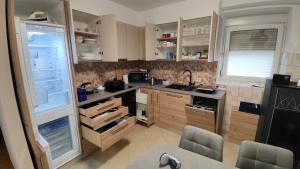a kitchen with an open refrigerator with two chairs in it at Frane House in Knežak