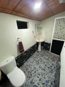 een badkamer met toilet en wastafel bij Zyon Bay Hostel Hiriketiya - Surf, Sun & Smile in Hiriketiya