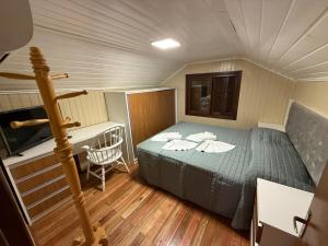 a bedroom with a bed and a desk in a room at Sua Casa no Centro Gramado, 1km Rua Coberta in Gramado