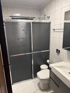 a bathroom with a shower with a toilet and a sink at Sua Casa no Centro Gramado, 1km Rua Coberta in Gramado +18 photos