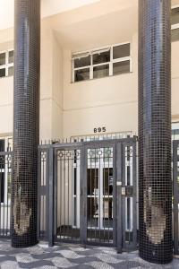 Una puerta delante de un edificio con dos columnas. en Vanguard Ipiranga, en São Paulo