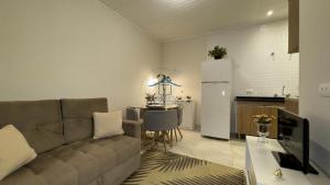 坎波斯杜若尔当Cantinho Dolce Amore的客厅里有一张沙发和一个厨房 更多7张照片