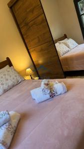 坎波斯杜若尔当Cantinho Dolce Amore的卧室设有两张床,配有大型木制床头板