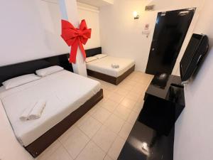 a bedroom with a bed with a red bow on it at M Candy Hotel in Malacca