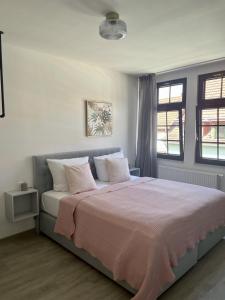 a bedroom with a large bed with a pink blanket at discovAIXR - Super Zentral mit Parkplatz, Küche, Netflix und mehr in Eisenach