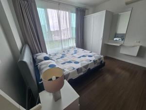 a small bedroom with a bed and a window at Downtown Hua Hin Condo with Pool in Hua Hin