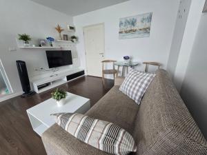 a living room with a couch and a table at Downtown Hua Hin Condo with Pool in Hua Hin